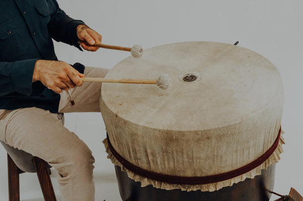 Hands playing the DarbBahar membrane with mallets