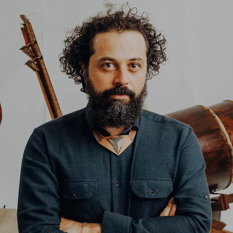 Portrait of Görkem Şen with his instruments behind him